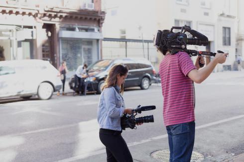 People with cameras shooting a documentary on the street