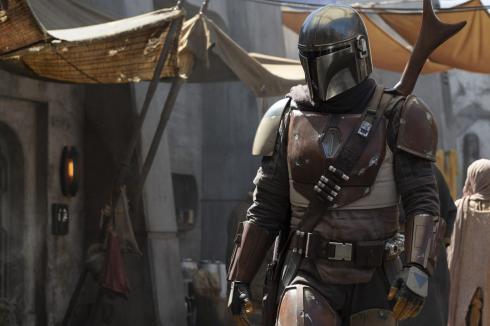 A still from the TV series The Mandalorian, showing the main character in a market.